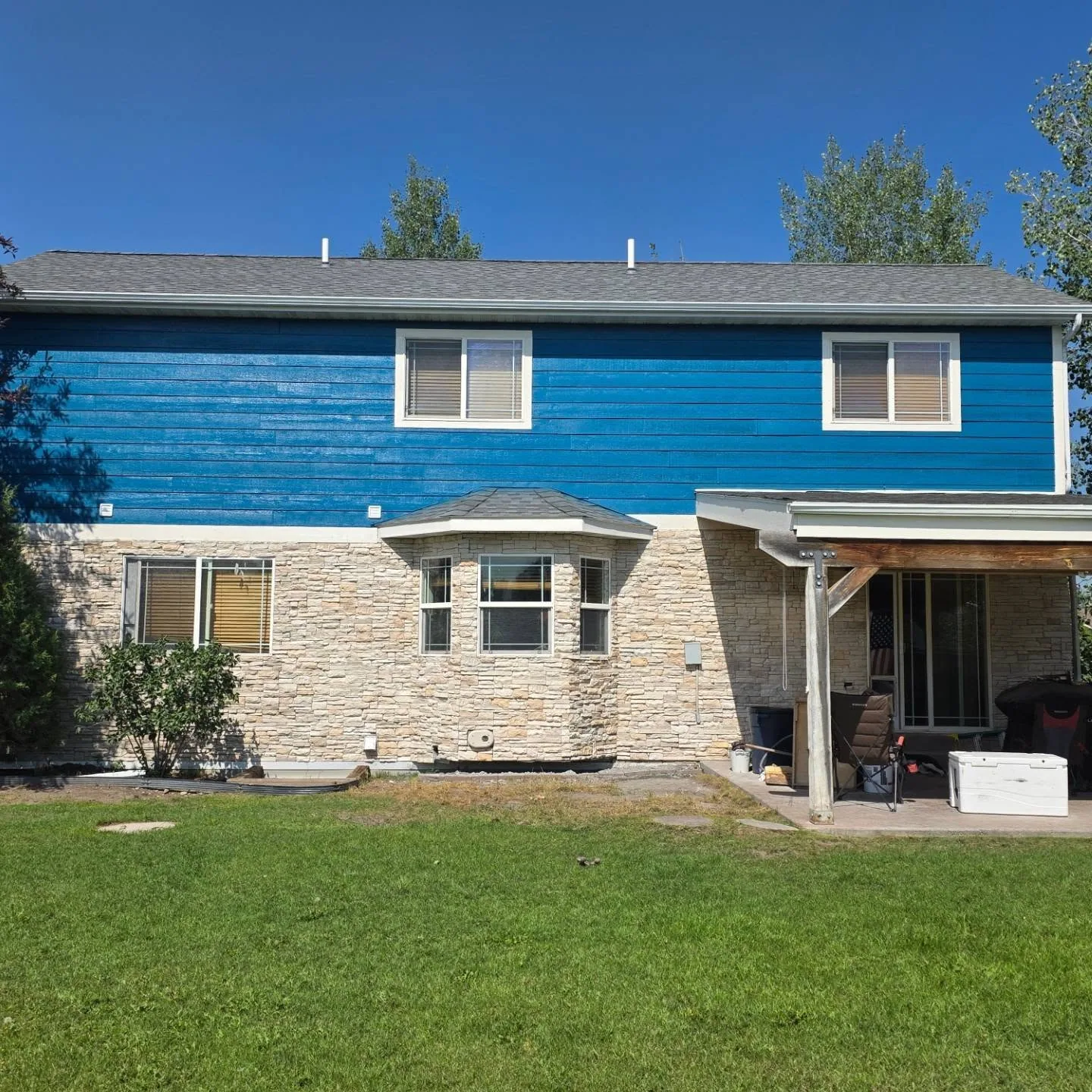 Blue lap siding stone veneer bay window home