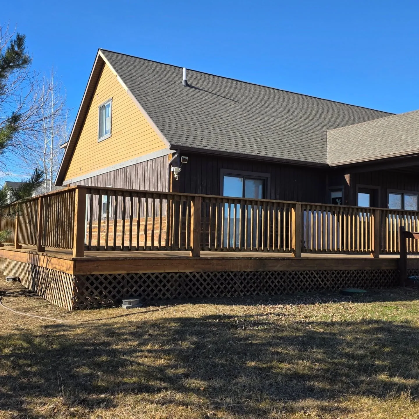 Corner view raised wood deck yellow gable house