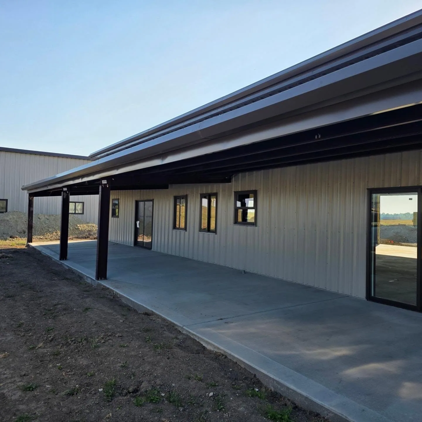 Covered concrete patio brown steel posts metal building