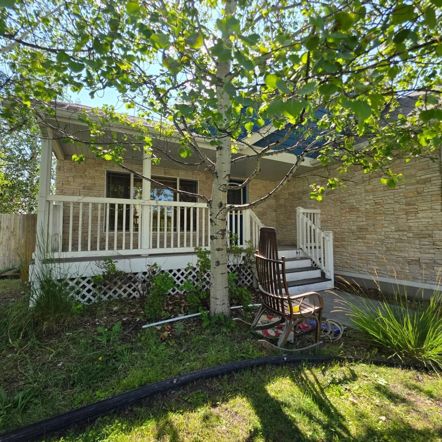 Covered front porch stacked stone facade rocking chair