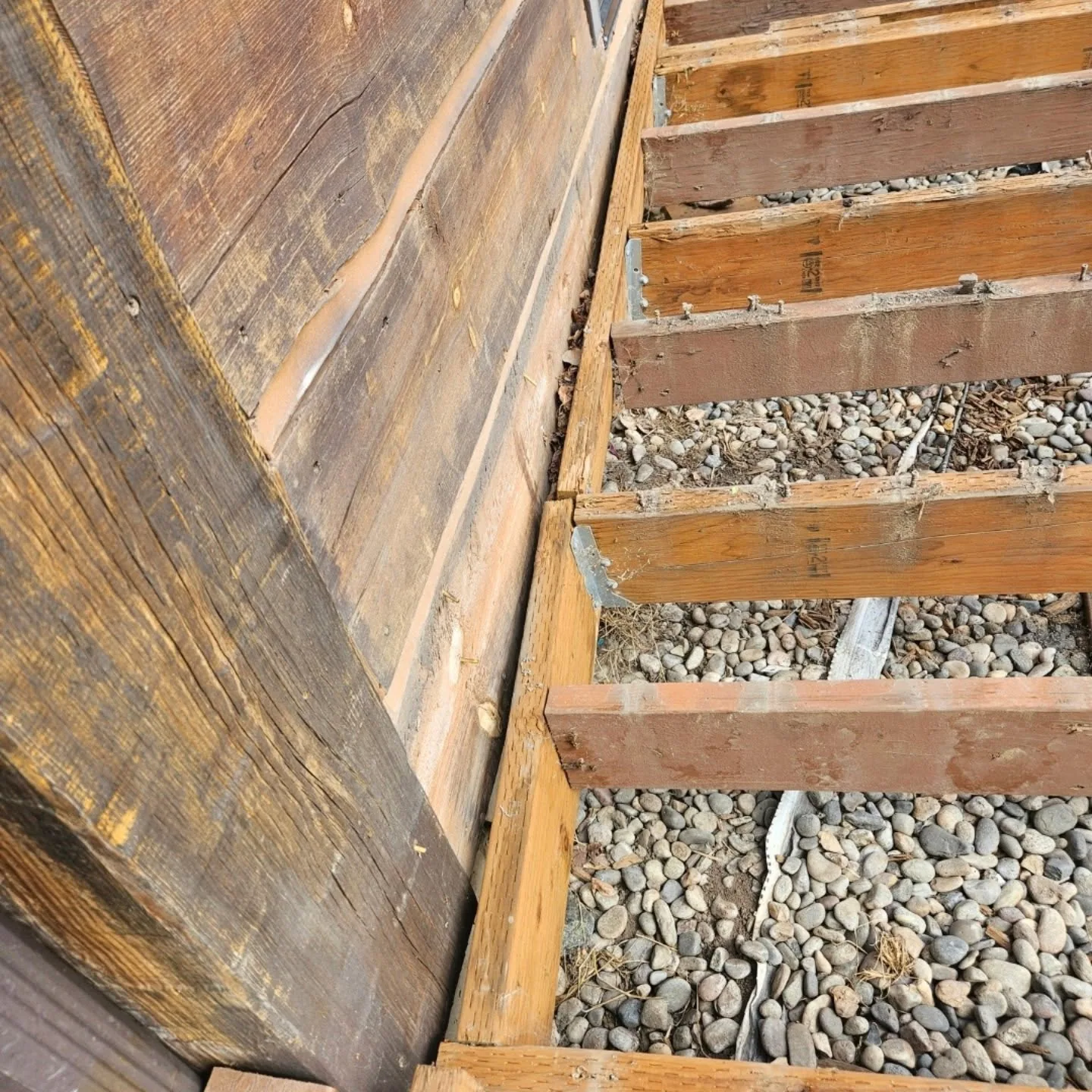 Exposed deck joists river rock ledger log wall