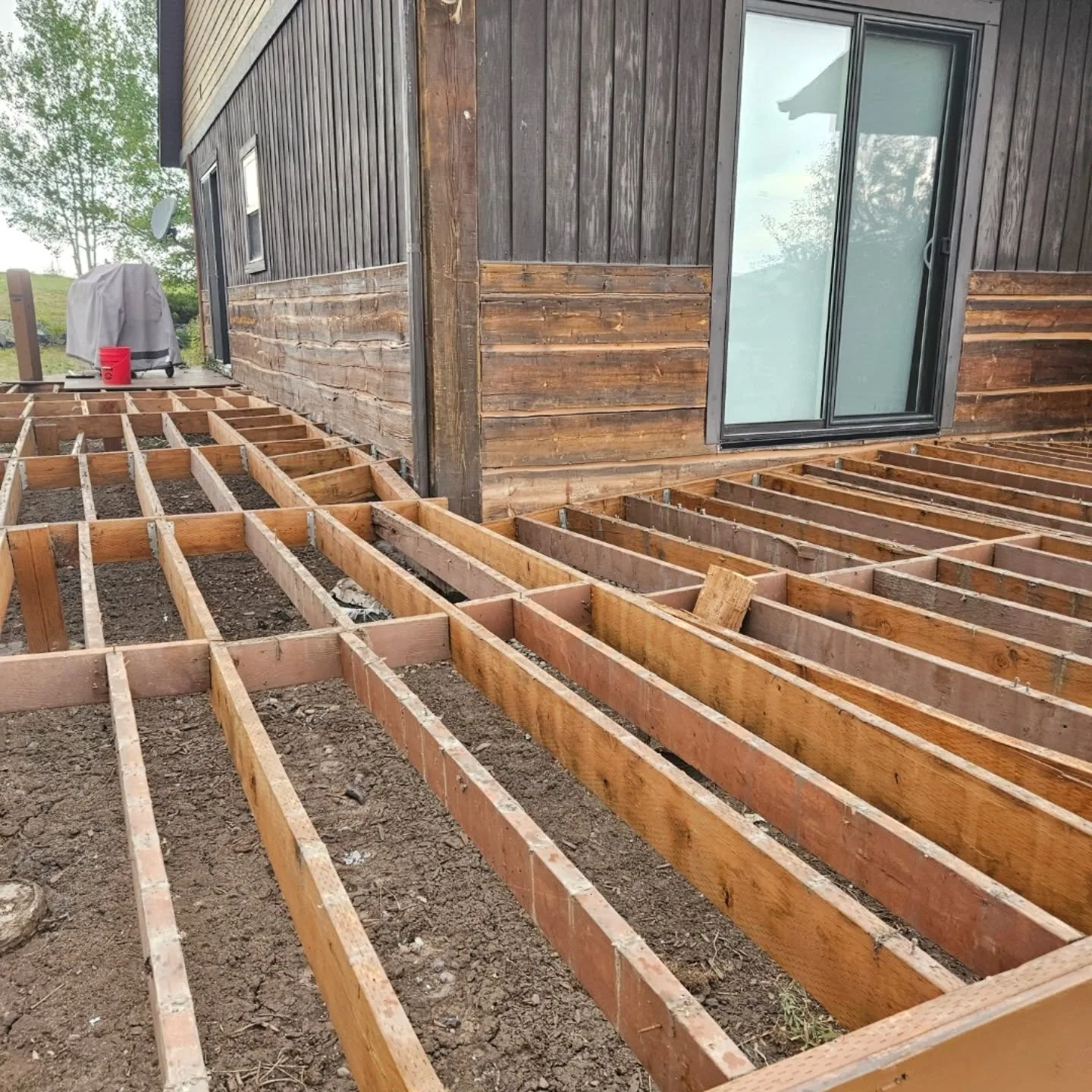 Ground level wraparound deck frame rustic wood siding