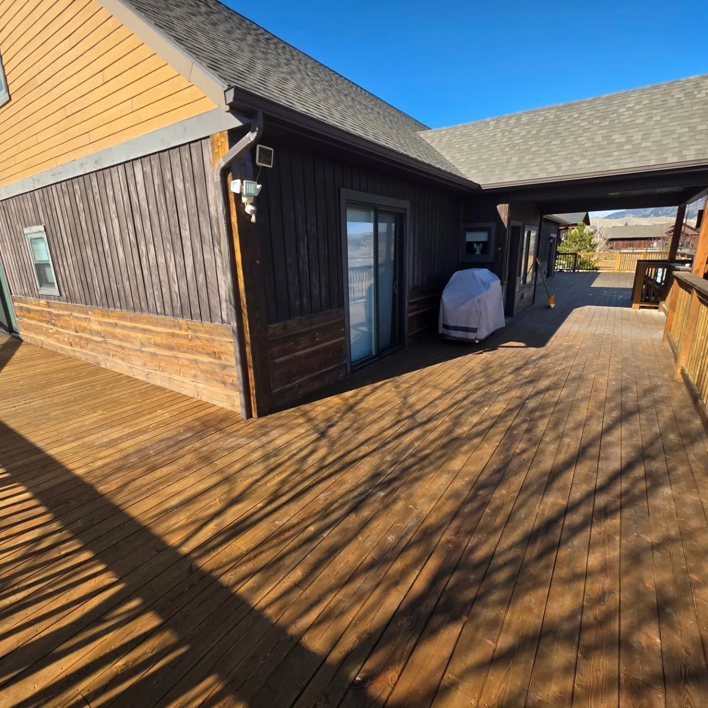 Stained deck covered breezeway grill vertical board siding