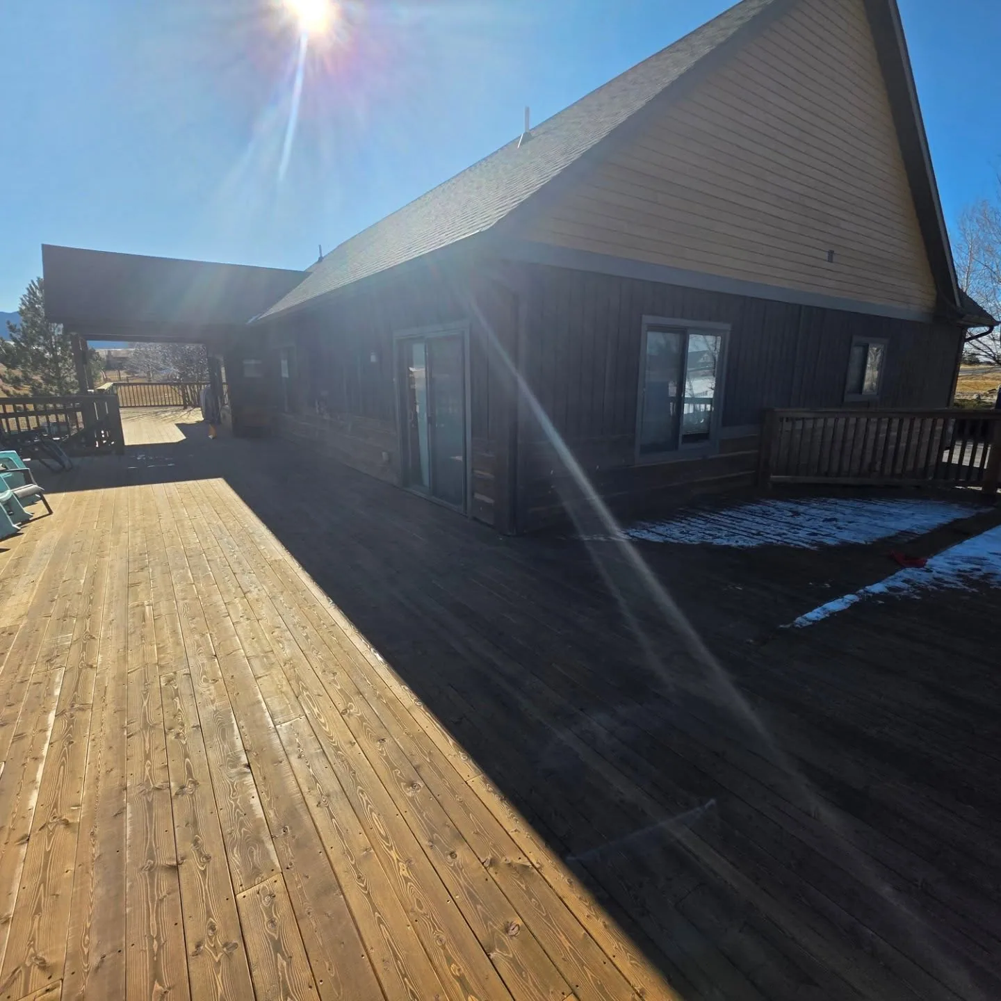 Sunlit wraparound wood deck dark sided home snow