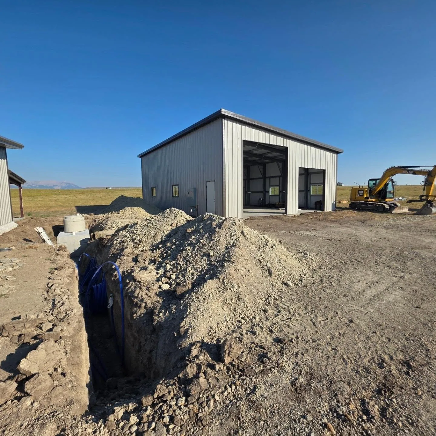 Utility trench blue water line steel shop excavator