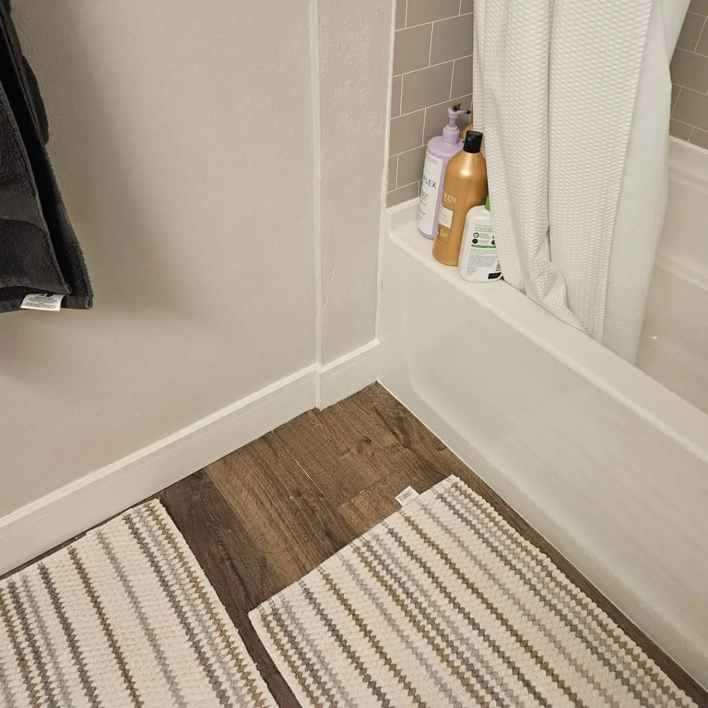 Wood look vinyl plank bathroom floor white baseboard