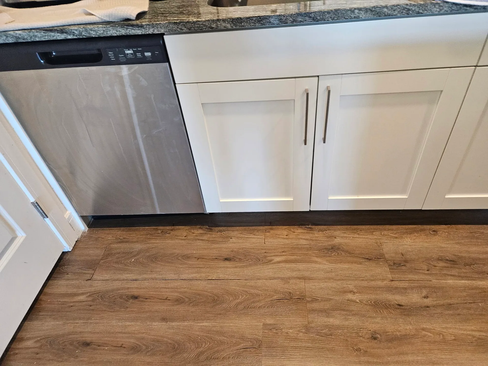Wood look vinyl plank kitchen floor white cabinets
