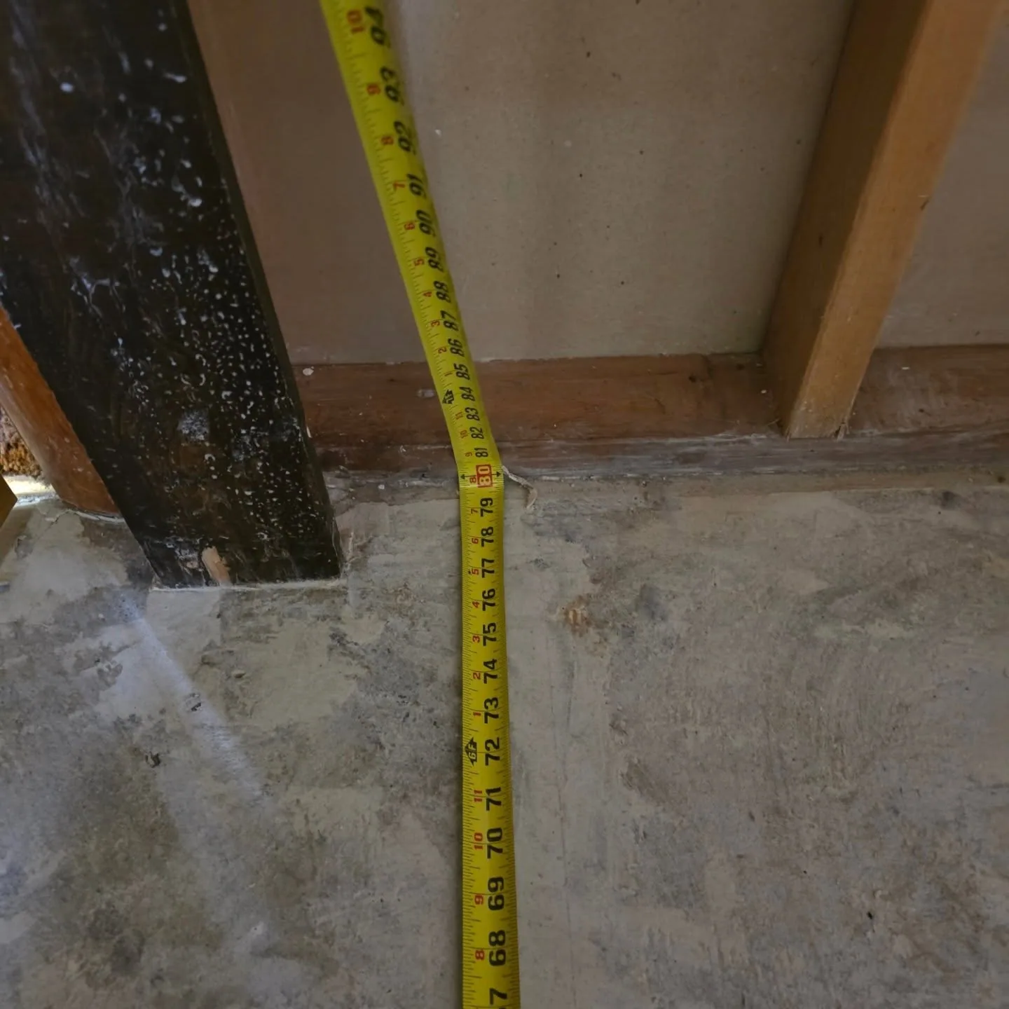 Yellow tape measure concrete floor bottom plate
